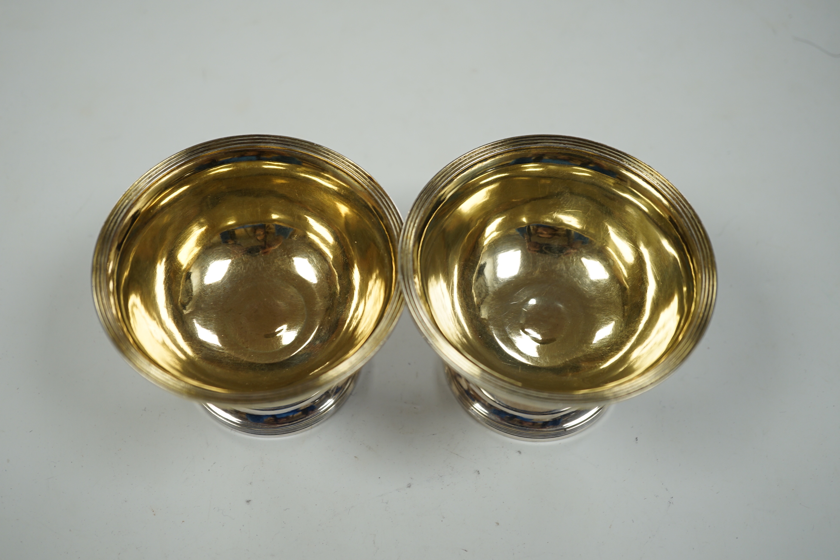 A pair of George III silver circular pedestal salts, John Kidder?, London, 1799, diameter 78mm and a small Hanau silver two handled dish.